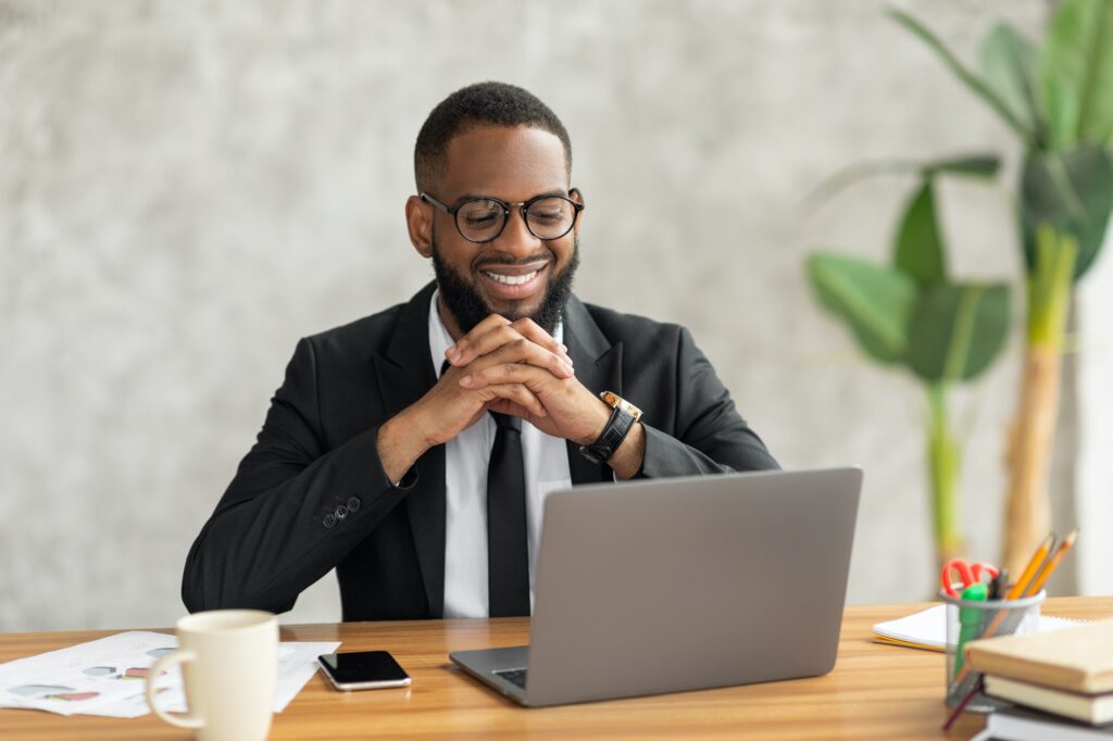Smiling black man watching video on computer